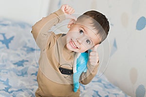 Little boy holding a dolphin toy in his playroom