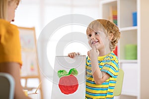 Little boy holding a drawing for mum