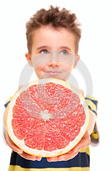 Little boy holding grapefruit