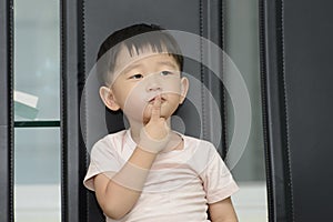Little boy  holding index finger over mouth, telling you to make silence