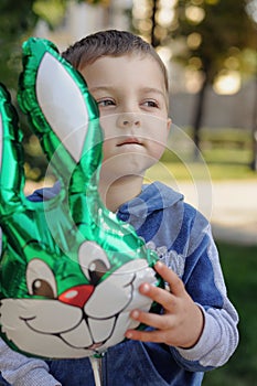 Little boy holding an inflatable rabbit