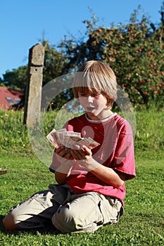 Little boy holding lots of money