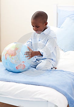 Little boy holding a terrestrial globe