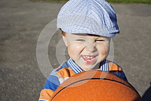 A little boy holds a basketball