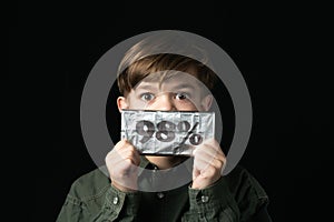 Little boy holds a chocolate bar in foil