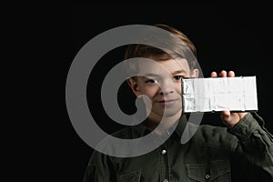 Little boy holds a chocolate bar in foil