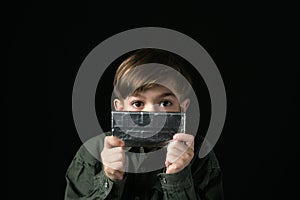 Little boy holds a chocolate bar in foil