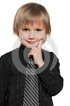 Little boy holds finger on his cheek