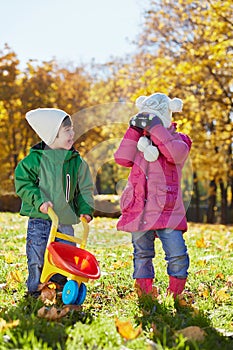 Little boy holds plastic wheelbarrow and shows his