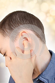 Little boy holds on to the ear, part of the face close-up, medical concept, hearing control, middle ear inflammation, otitis media