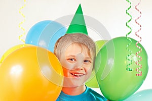 Little boy in holiday cap with festive balls and streamer