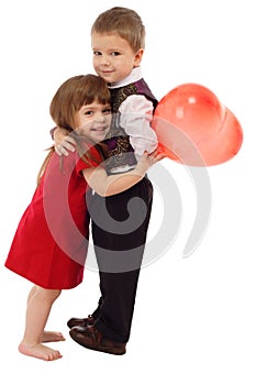 Little boy hugging girl with red balloon