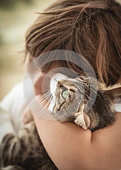 Little boy hugging his cute cat. Close up portrait.