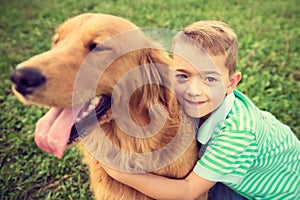 Little boy hugging his golden retriever pet dog