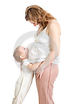 Little boy hugging pregnant mother's belly and looking up