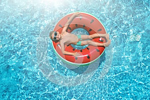 Little boy with inflatable ring in swimming pool, top view. Summer vacation
