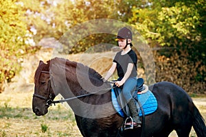 A little boy jockey on horseback . Horseback riding lessons .