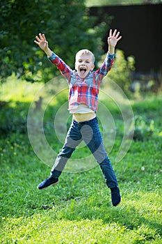 Little boy joyfully jumping in the summer