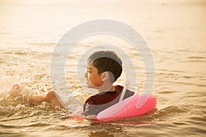 Little boy jumping over the beach wave