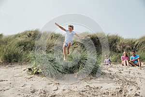 Little Boy Jumping Over a Sand Dune