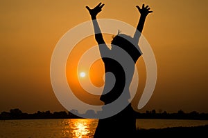 Little boy jumping before the sunset silhouette