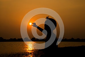 Little boy jumping before the sunset silhouette