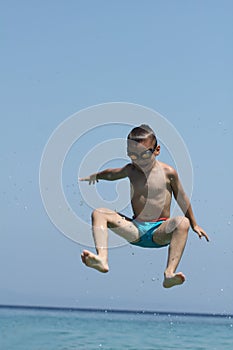 Little boy jumps in sea