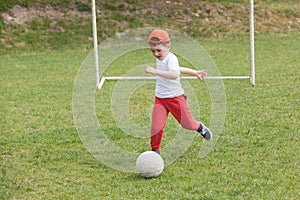 Little boy kicking ball in the park. playing soccer football in the park. Sports for exercise and activity.