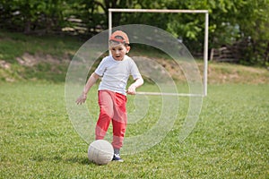 Little boy kicking ball in the park. playing soccer football in the park. Sports for exercise and activity