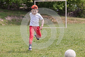 Little boy kicking ball in the park. playing soccer football in the park. Sports for exercise and activity