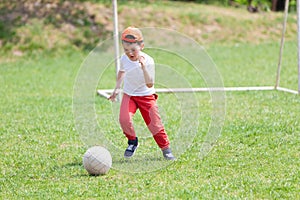Little boy kicking ball in the park. playing soccer football in the park. Sports for exercise and activity