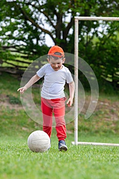 Little boy kicking ball in the park. playing soccer (football) in the park. Sports for exercise and activity