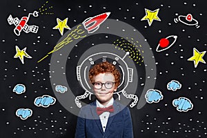 Little boy kid astronaut on blackboard background with space scetch