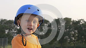 Little boy kid, child in orange t-shirt and blue helmet is riding scooter. Childhood memories, safe and funny experience .