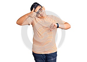 Little boy kid wearing casual clothes and glasses doing thumbs up and down, disagreement and agreement expression