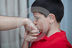 Little boy kiss his father`s hand during Eid mubarak Turkish Ramazan or Seker Bayram