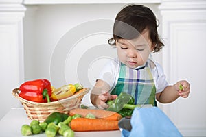 Little boy in kitchen apron playing with photo