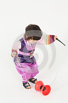 Little boy in korean silk suit plays with diabolo