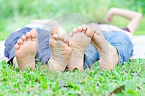 Little boy lay on grass show feet