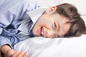 Little boy laying down on the bed cute beautiful face