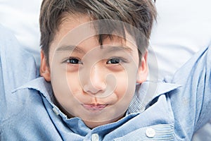 Little boy laying down on the bed cute beautiful face