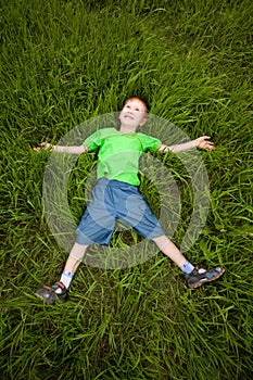Little boy laying on the grass