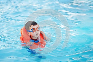 little boy learn to swim in the pool
