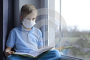 Little boy is  learning in a medical mask.