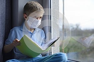 Little boy is  learning in a medical mask.