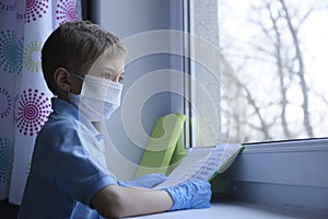 Little boy is  learning in a medical mask.