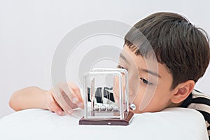 Little boy learning newton balance ball for science physic photo