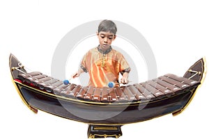 Little boy learning Thai instument Xylophone, Ranat, on white background