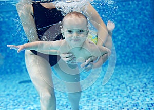 Little boy learning to swim in a swimming pool