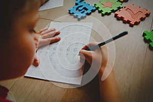 Little boy learning write and culculate numbers